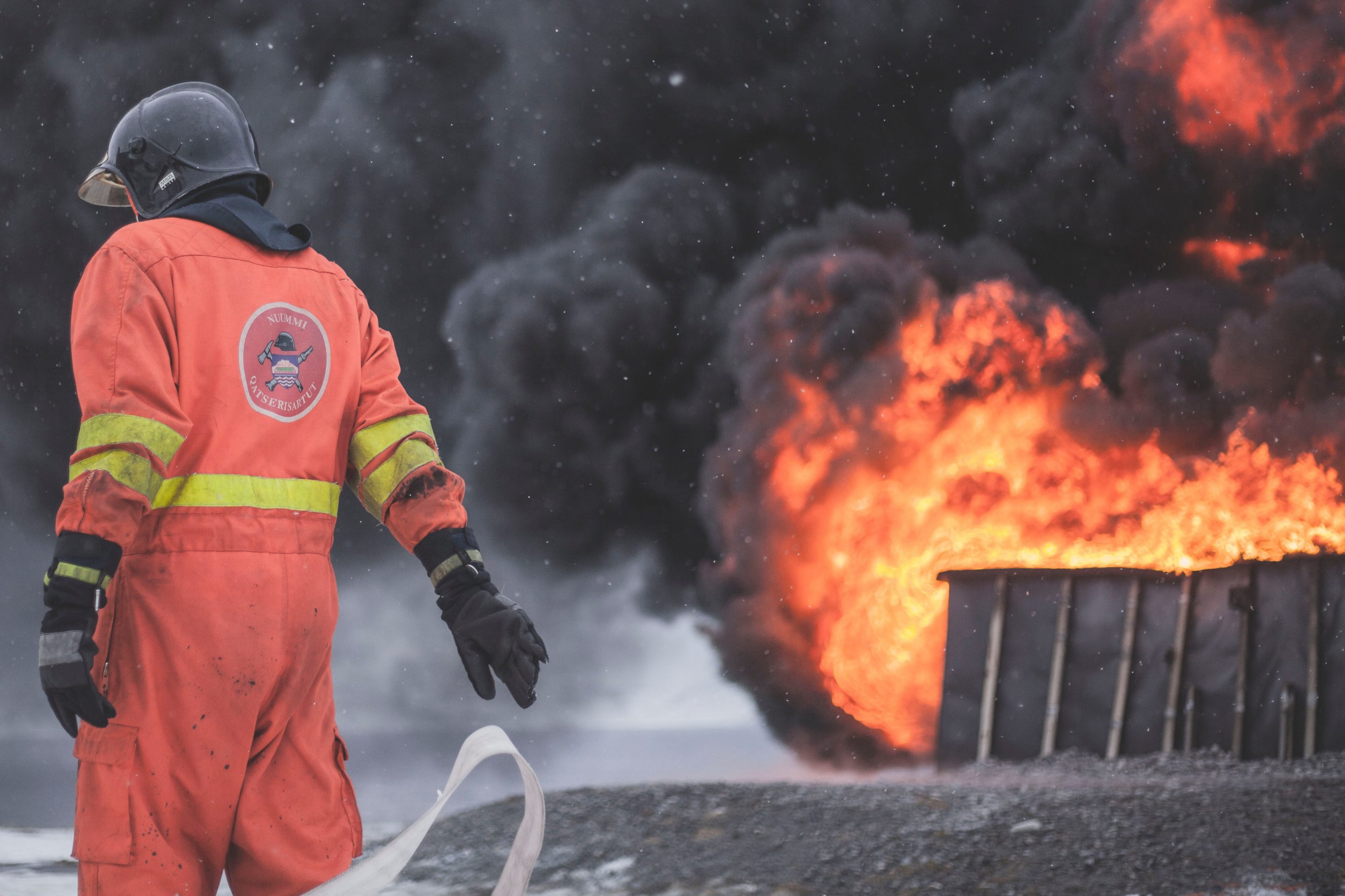 man in safety suit with blazing fire in the background 