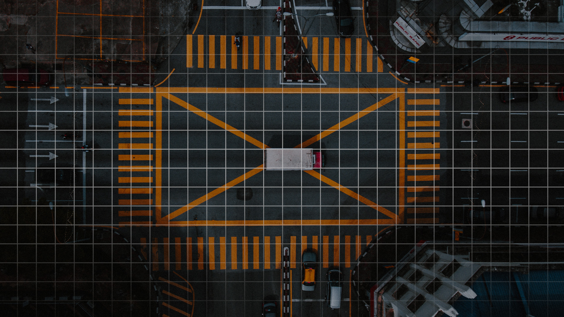 birds eye view of intersection crossing with cars