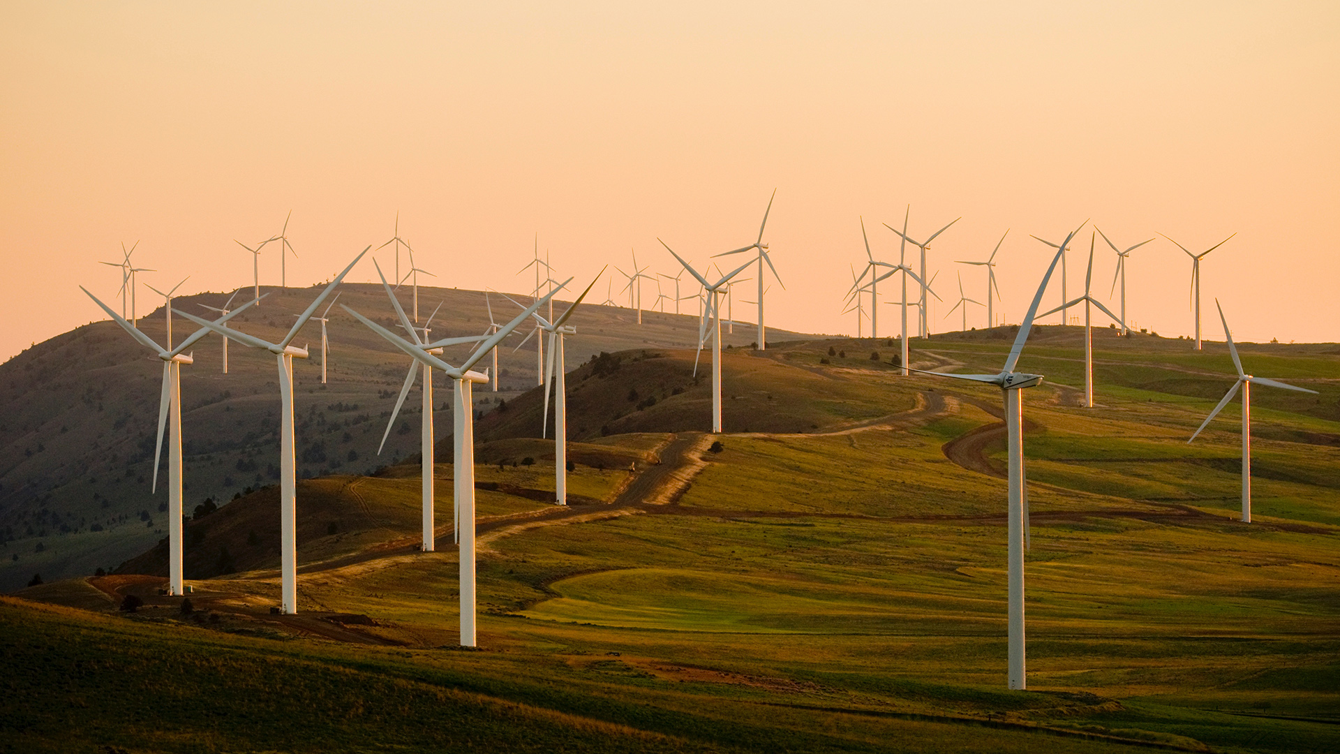  wind turbines across the countryside at sunset 