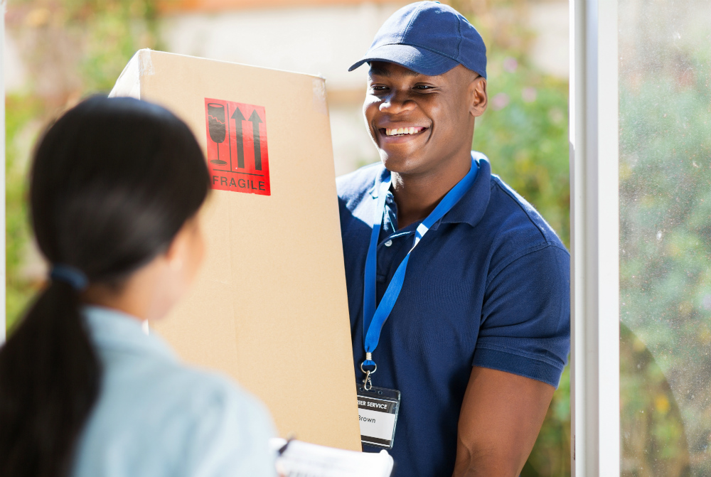 delivery man giving woman fragile box