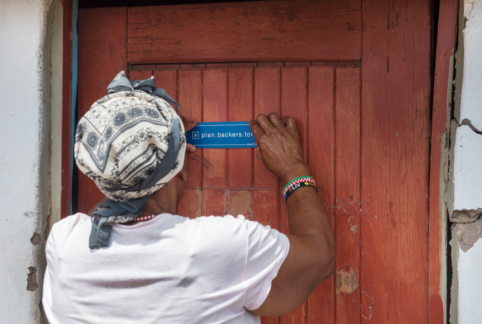 woman putting personalised sticker on front door