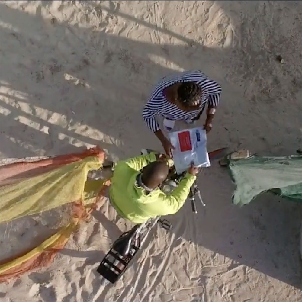 two people looking at instructions on a beach