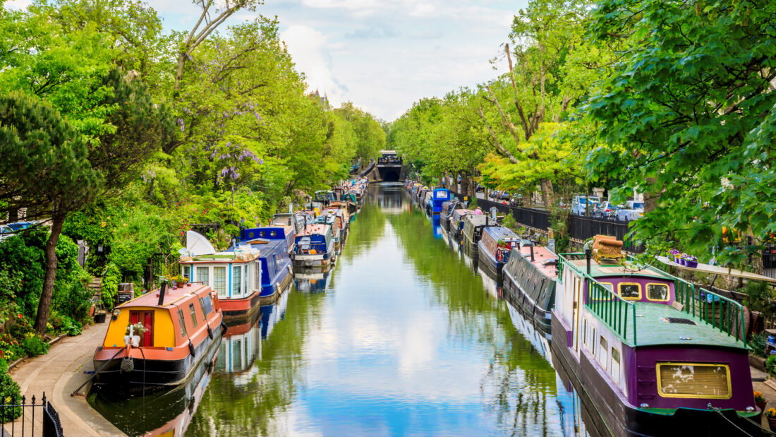 Canal with boats surrounded by trees 