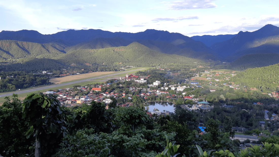 village surrounded by hills covered in forest