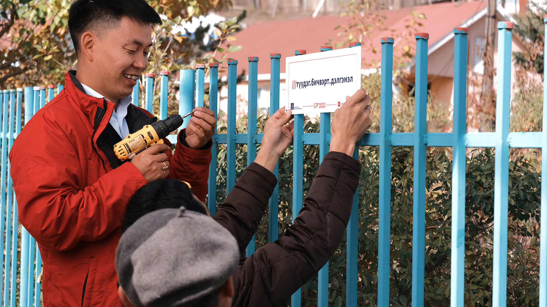 MongolPost person installing signage